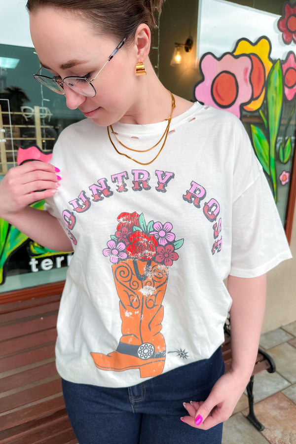 Woman wearing a country rose graphic tee shirt with dark denim jeans.