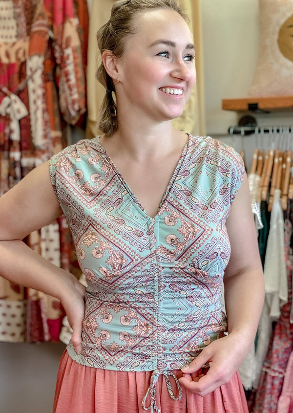 Girl-wearing-a-sage-and-rust-paisley-ruched-top